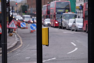 Pedestrian push button on pole against road in city