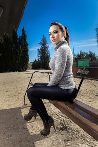 Portrait of young woman sitting on bench