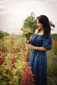 A young woman prune flowers in a floristic flower farm. woman florist.