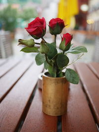 Close-up of rose flowers and buds in vase on table
