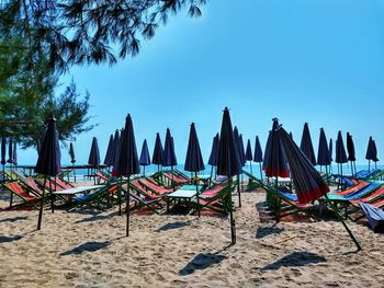 Panoramic view of chairs on beach against clear blue sky