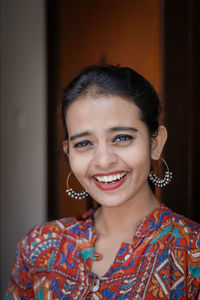 Close-up portrait of smiling woman standing at home