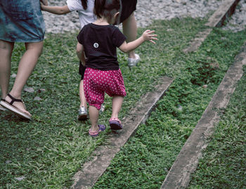 Low section of two people walking on grassland