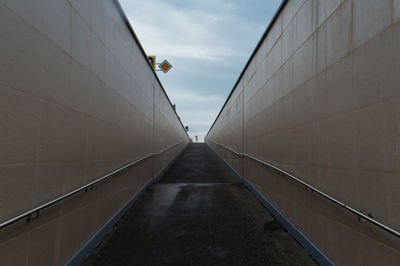 Footpath amidst buildings against sky