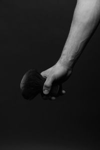 Low section of man holding hands against black background