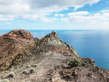 Rock formations by sea against sky