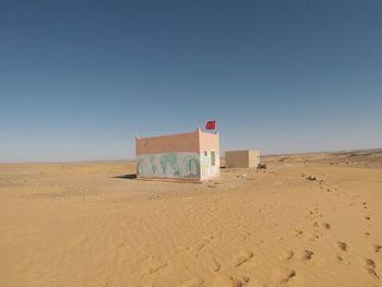 Built structure on beach against clear sky