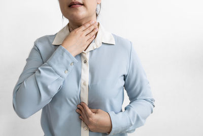 Midsection of woman standing against white background