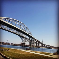 Bridge over river against clear blue sky