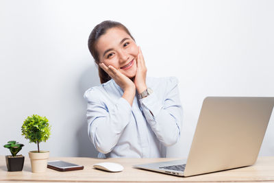 Portrait of a smiling young woman sitting on table