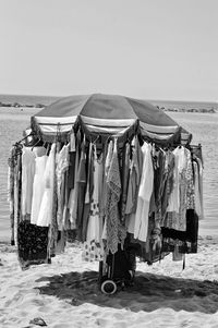 Clothes hanging on clothesline at beach against clear sky