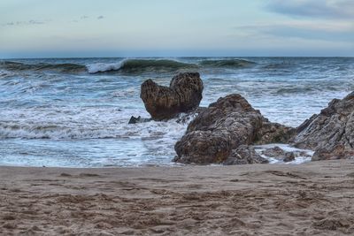 Rocks on beach against sky