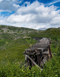 Wooden structure on field against sky