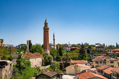 View of buildings in city against clear blue sky