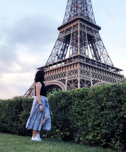 Low angle view of woman looking at eiffel tower