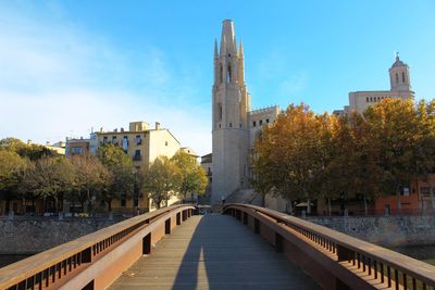 Bridge over river in city against sky