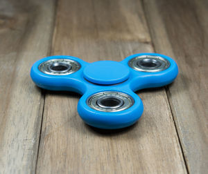 High angle view of blue fidget spinners on wooden table