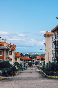 Street amidst buildings in town against sky