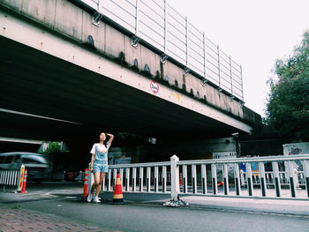 Full length of young woman standing on city street