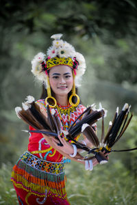 Portrait of smiling young woman wearing traditional clothing standing outdoors