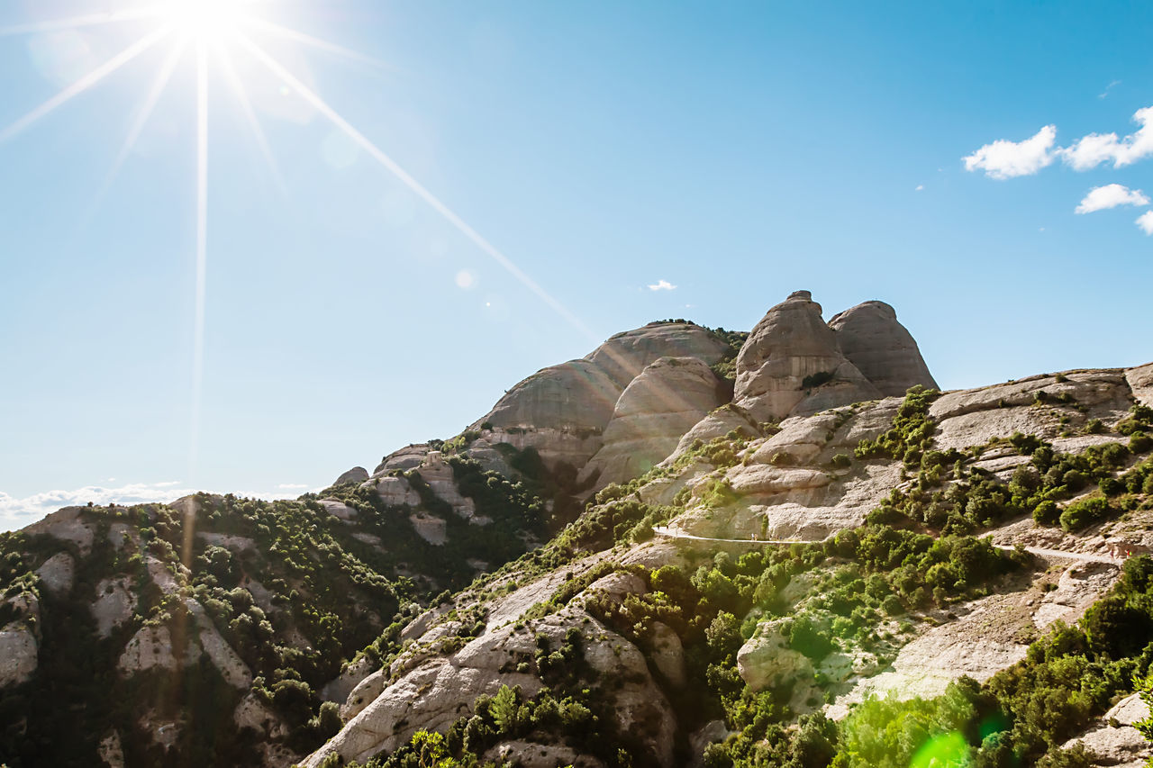 SCENIC VIEW OF MOUNTAINS AGAINST BRIGHT SUN