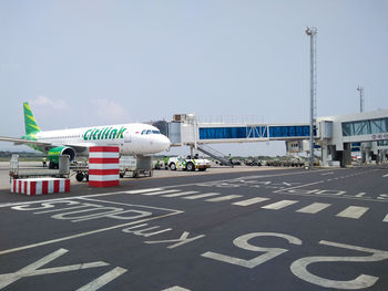 Road sign at airport against sky