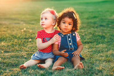 Portrait of happy friends sitting on land