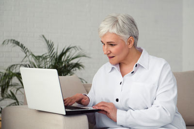 Gray-haired businesswoman working at a desk with a computer