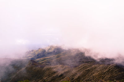 Fog from volcanic mountain against sky