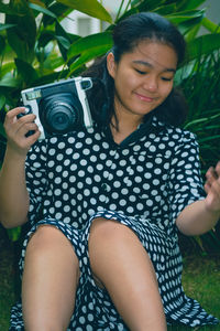 Portrait of woman photographing while holding camera