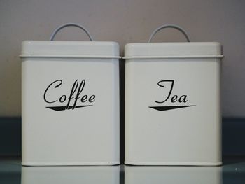 Coffee and tea containers with text on table