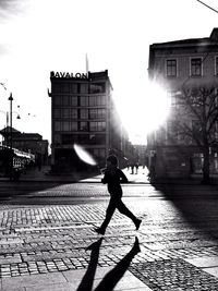 People walking on city street during sunset