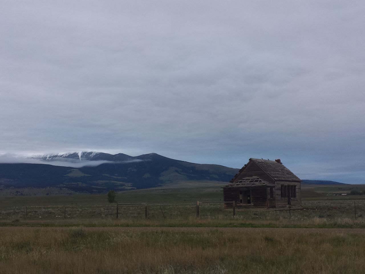 landscape, mountain, sky, built structure, architecture, building exterior, field, rural scene, tranquil scene, tranquility, scenics, cloud - sky, house, mountain range, agriculture, beauty in nature, nature, farm, grass, cloud