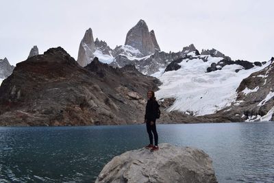 Full length of man standing on rock against sky