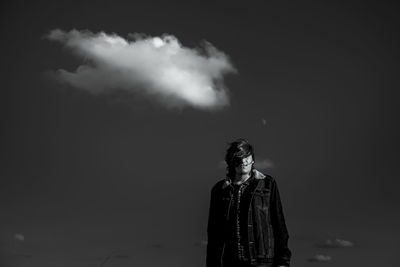 Portrait of young man standing against sky at night