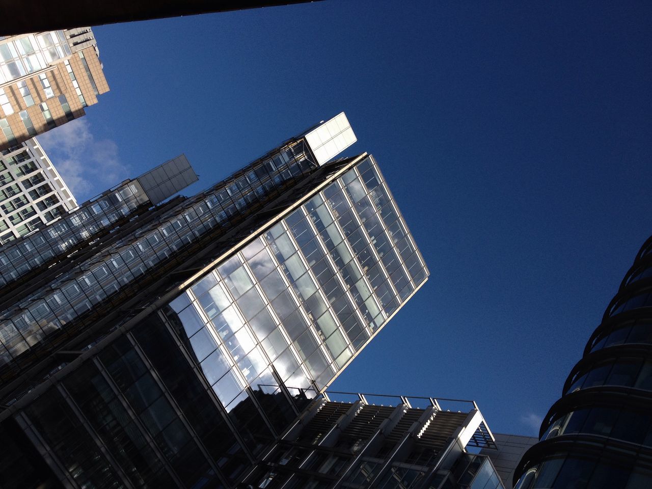 building exterior, architecture, built structure, low angle view, skyscraper, modern, city, office building, tall - high, tower, clear sky, building, blue, sky, glass - material, tall, reflection, financial district, day, outdoors