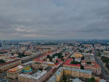 High angle view of city buildings against cloudy sky