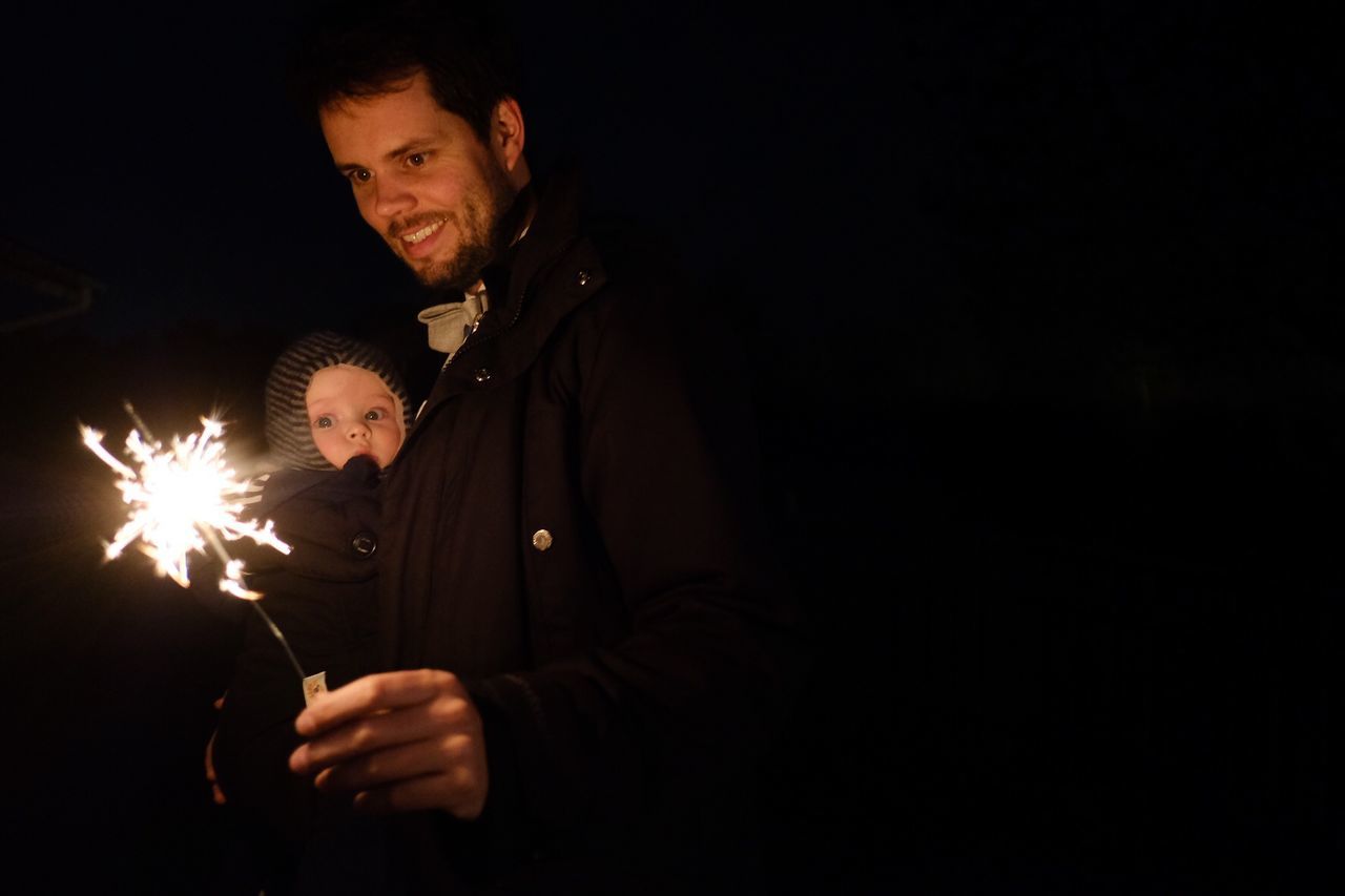 men, illuminated, glowing, night, males, two people, sparkler, burning, holding, celebration, mid adult men, lifestyles, real people, mid adult, copy space, portrait, dark, young adult, leisure activity, black background, sparks, firework