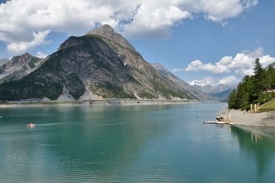 Scenic view of lake by mountains against sky