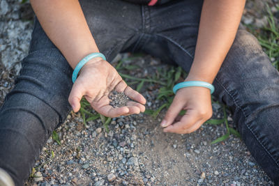 High angle view of hands holding rock