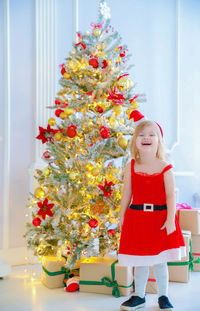 Full length of girl standing in christmas tree