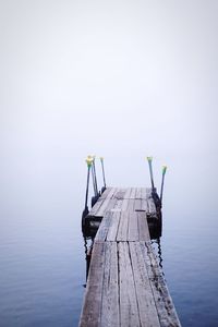 Pier on lake against sky