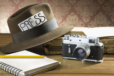 Press text on hat with diary and vintage camera on table