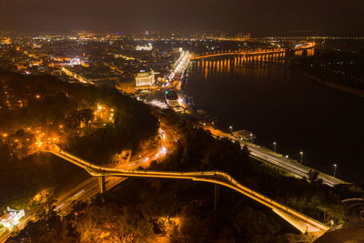 High angle view of illuminated city by river at night