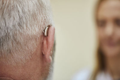 Female doctor and senior man with hearing aid