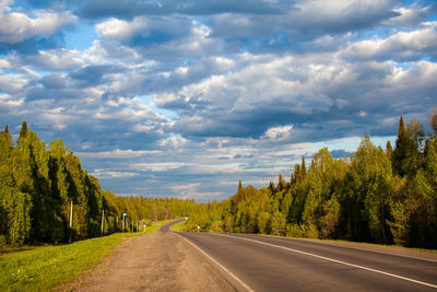 Road amidst trees against sky