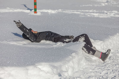 Blonde girl happy while lying on the snow