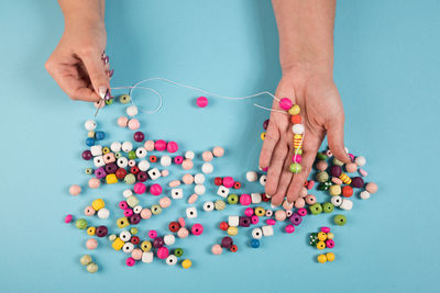 Cropped hands holding colorful beads at table