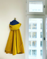 Clothes hanging on yellow window at home