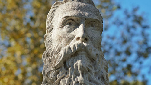 Close-up of angel statue against trees